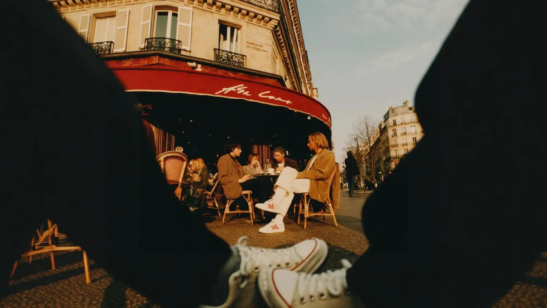 People talking at an outdoor café with open routes around them, suggesting a first meeting designed to preserve choice and manageable time.