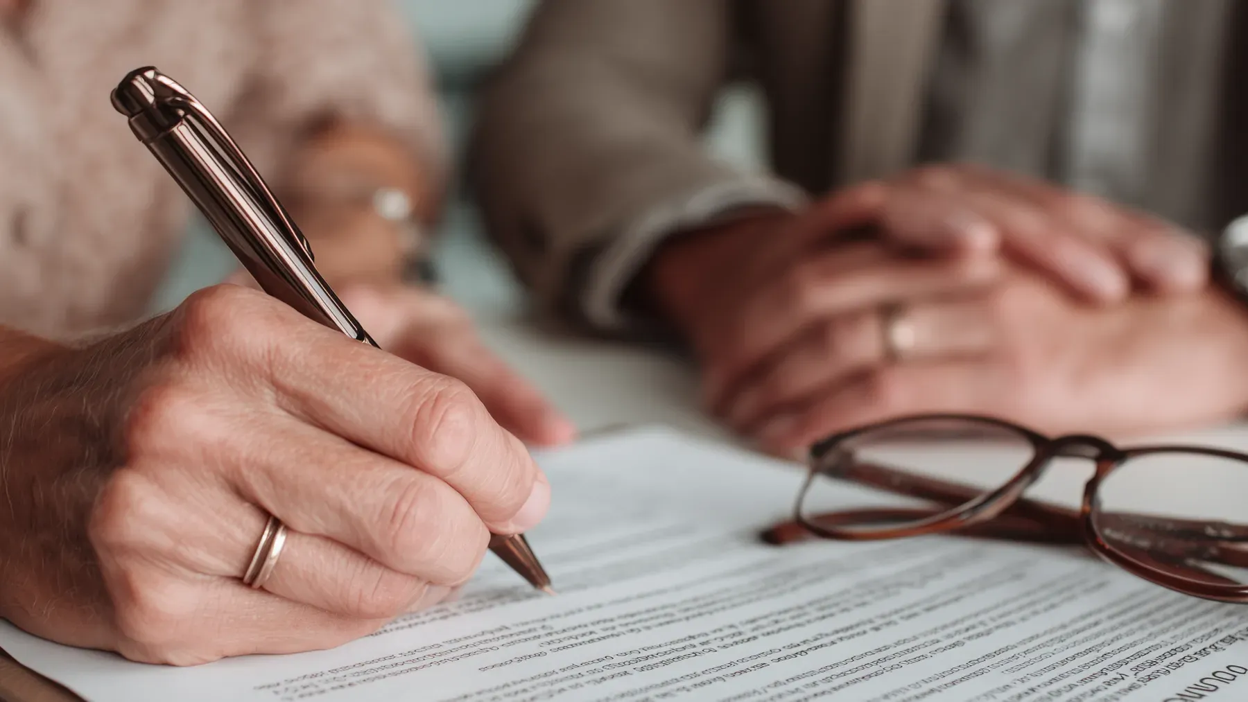 A pen meets a formal document while another person watches, turning a verbal disagreement about consent into inspectable evidence.