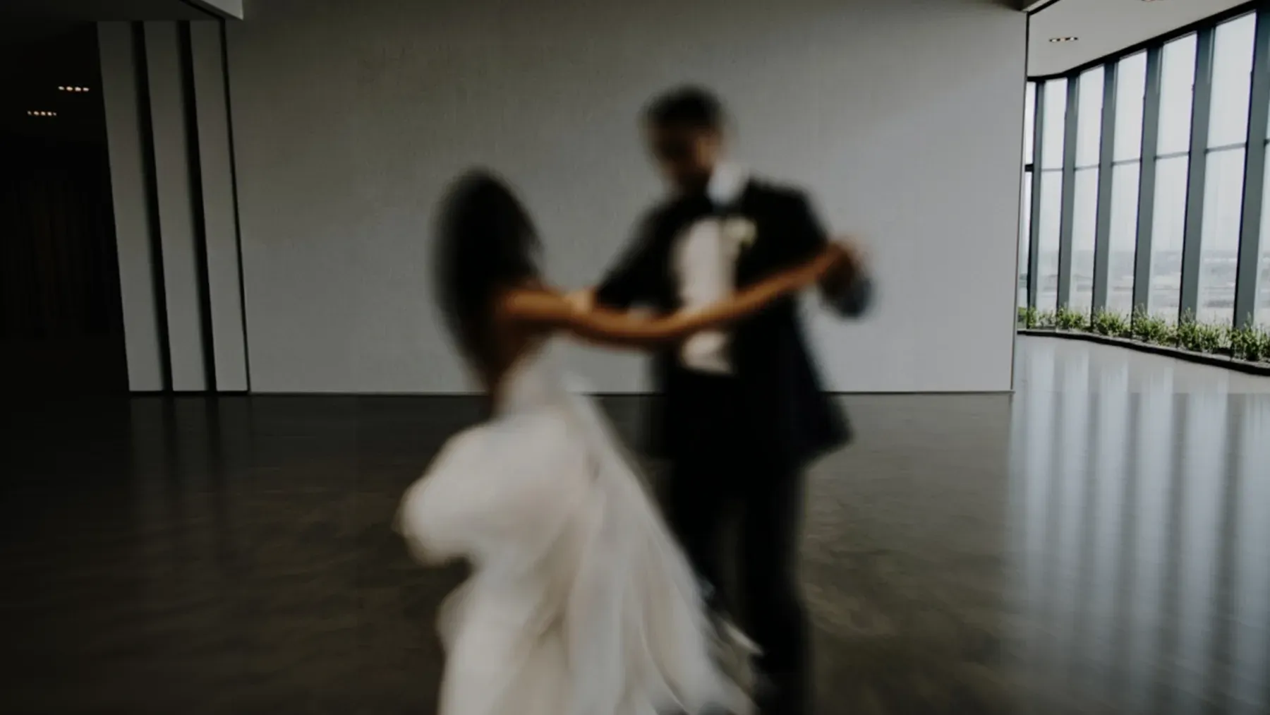 A formal couple turning through a blurred dance, representing the private exchange and unstable public meaning created by one visible partnership.