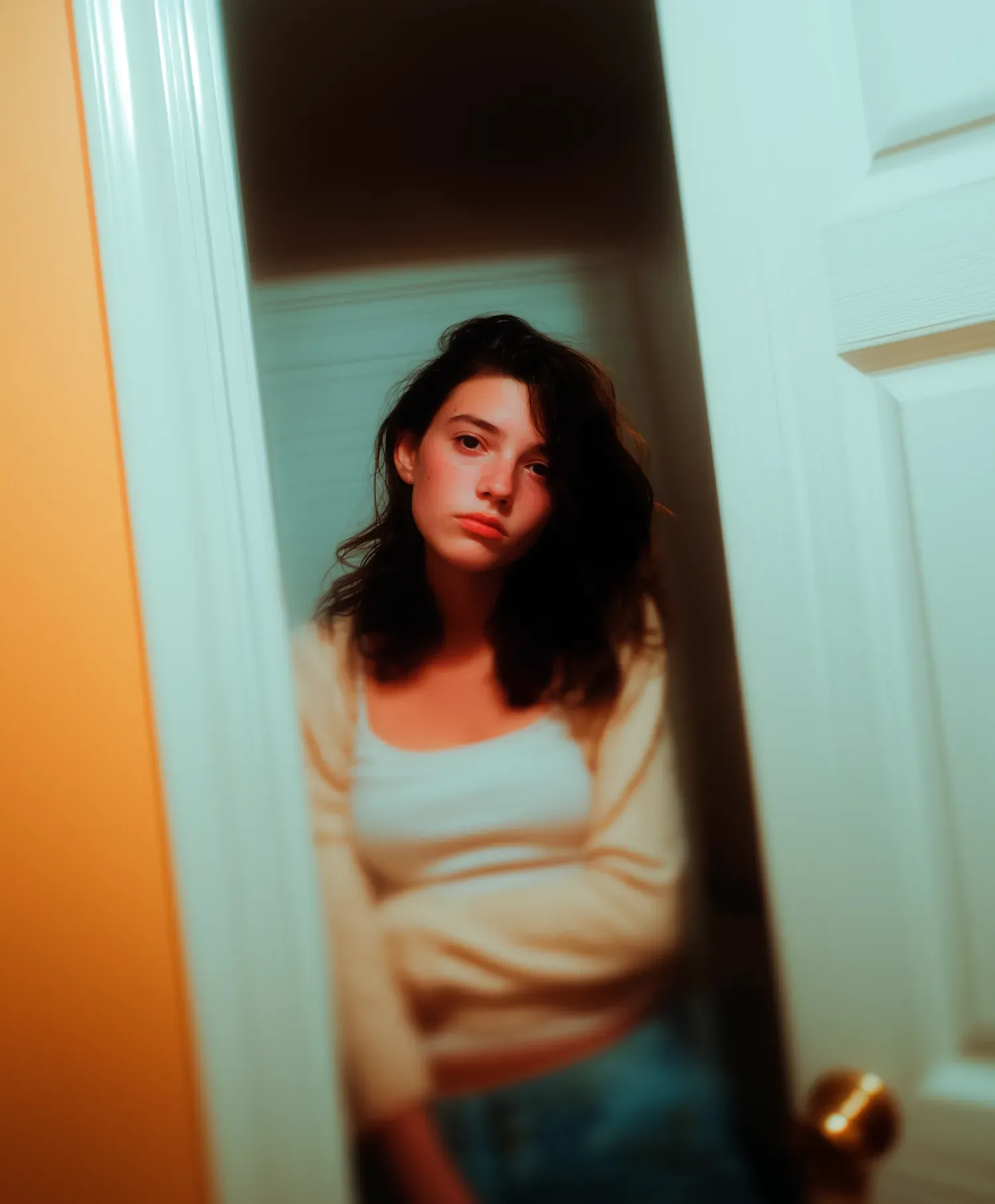 A woman leaning into a softly lit doorway, capturing how framing, relationship, and the observer's position determine what a character reveals.