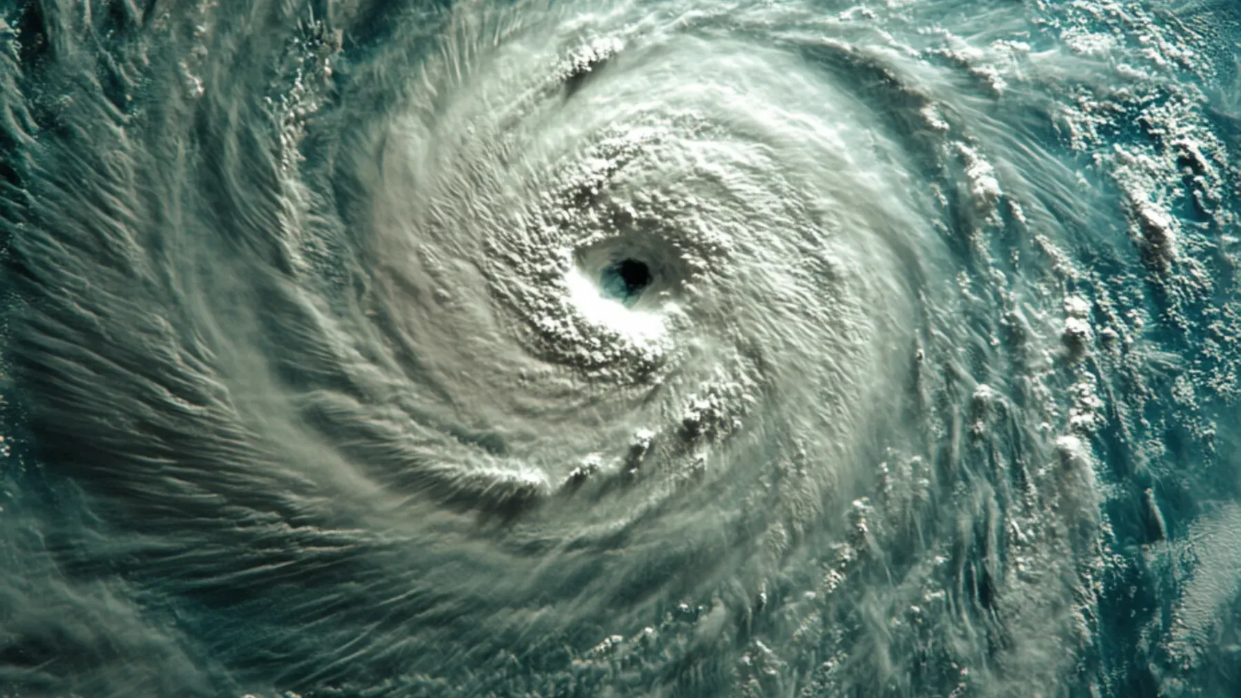 A cyclone seen from above establishes the moving physical system that gives every forecast, threshold, and public decision a deadline.