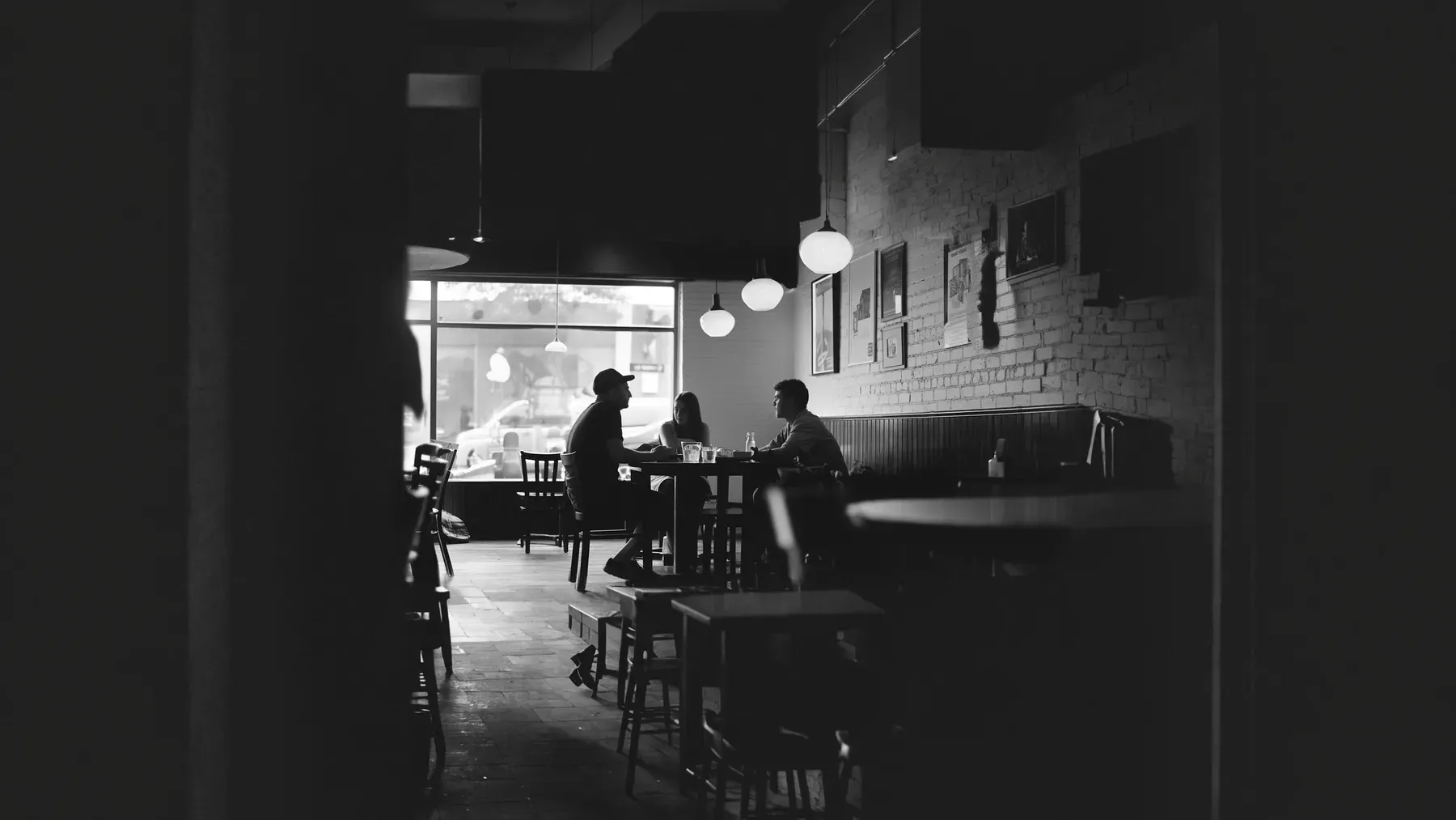 Neighbors talking in a cafe, representing the movement of observations, interpretations, and motives through a close community.