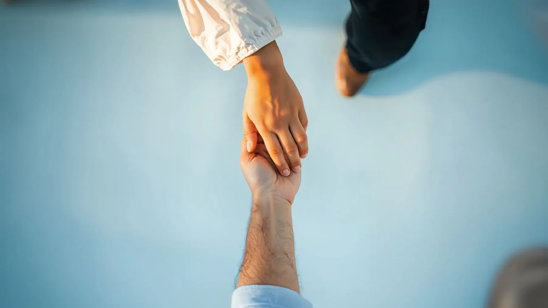 Two hands reaching toward each other, suggesting the relationship through which a death acquires meaning.