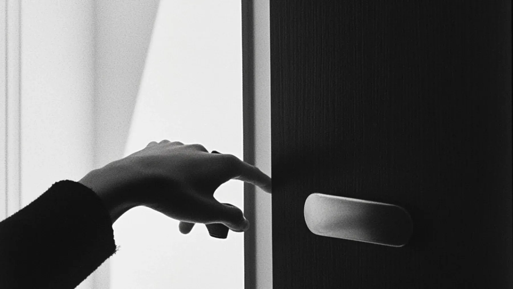 A hand approaching a dark door captures the final revision question: what action follows from the character's private interpretation?