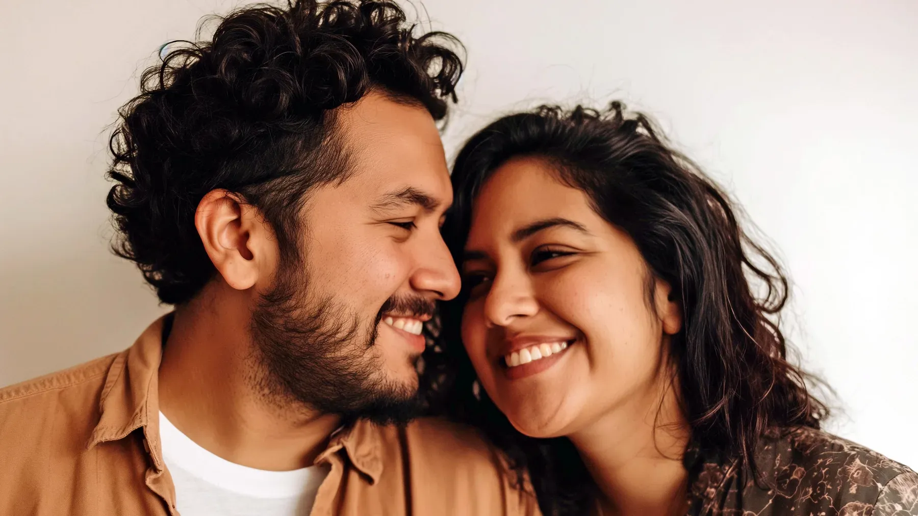 A joyful couple looking at each other after an intimate moment, representing the interpretation and changed behavior that follow a first kiss.