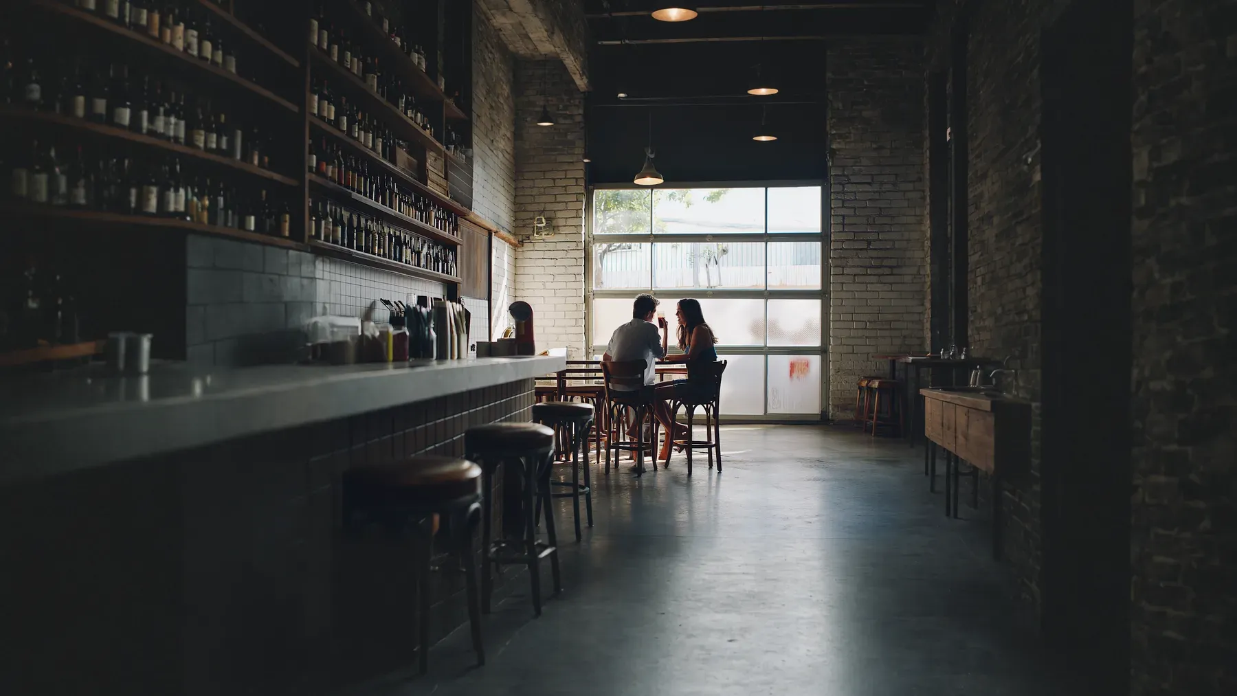 Friends sit together over coffee, representing the shared social history and ordinary pleasure that must remain visible as familiar actions acquire romantic weight.
