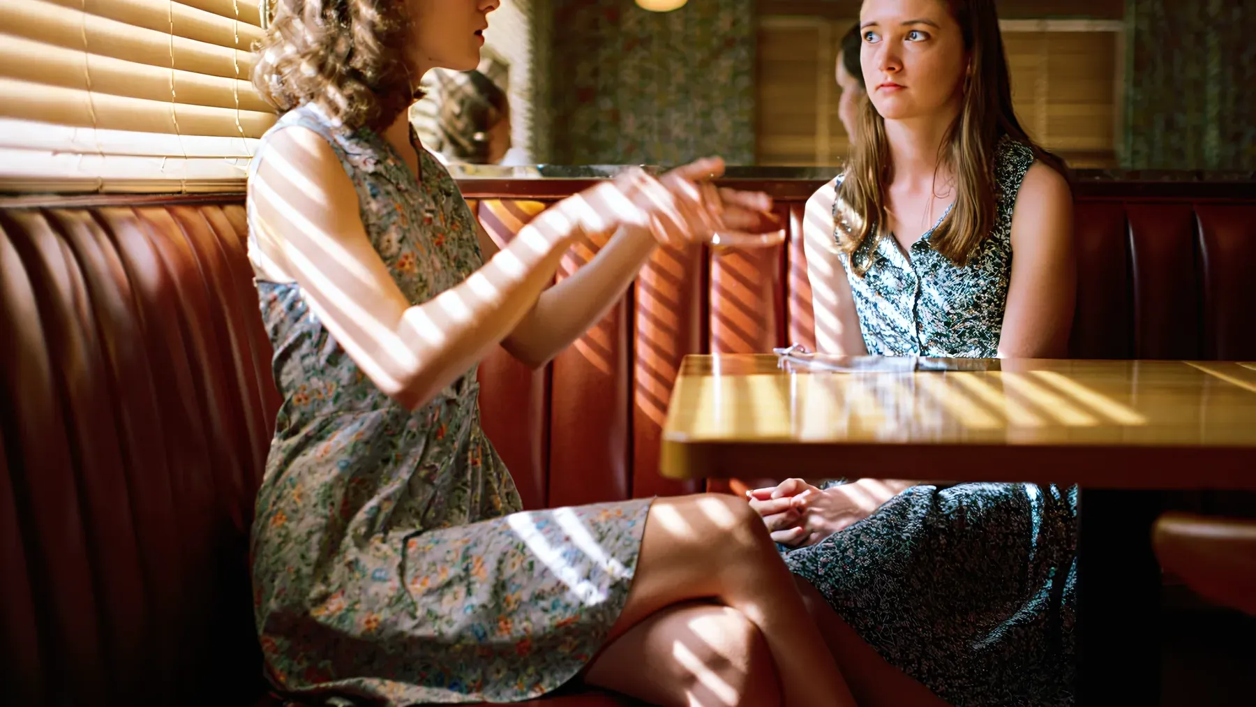 Two people in a tense conversation show how character voice changes with the listener while the speaker's underlying priorities remain legible.