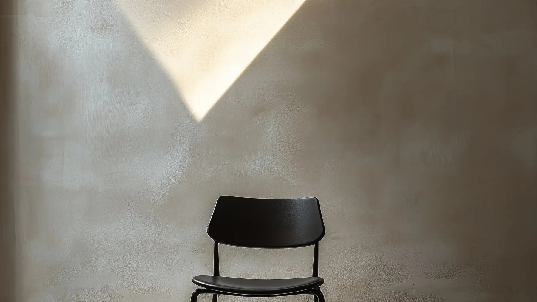 A single empty chair in a quiet room, showing how absence gains meaning from the expectation that someone should be there.