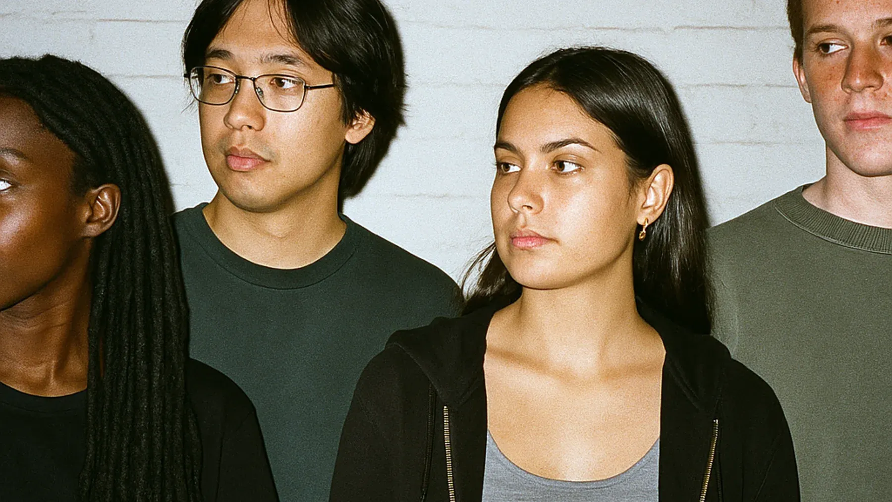 Four people facing different directions, reflecting an ensemble in which every perspective reveals a distinct part of one story.