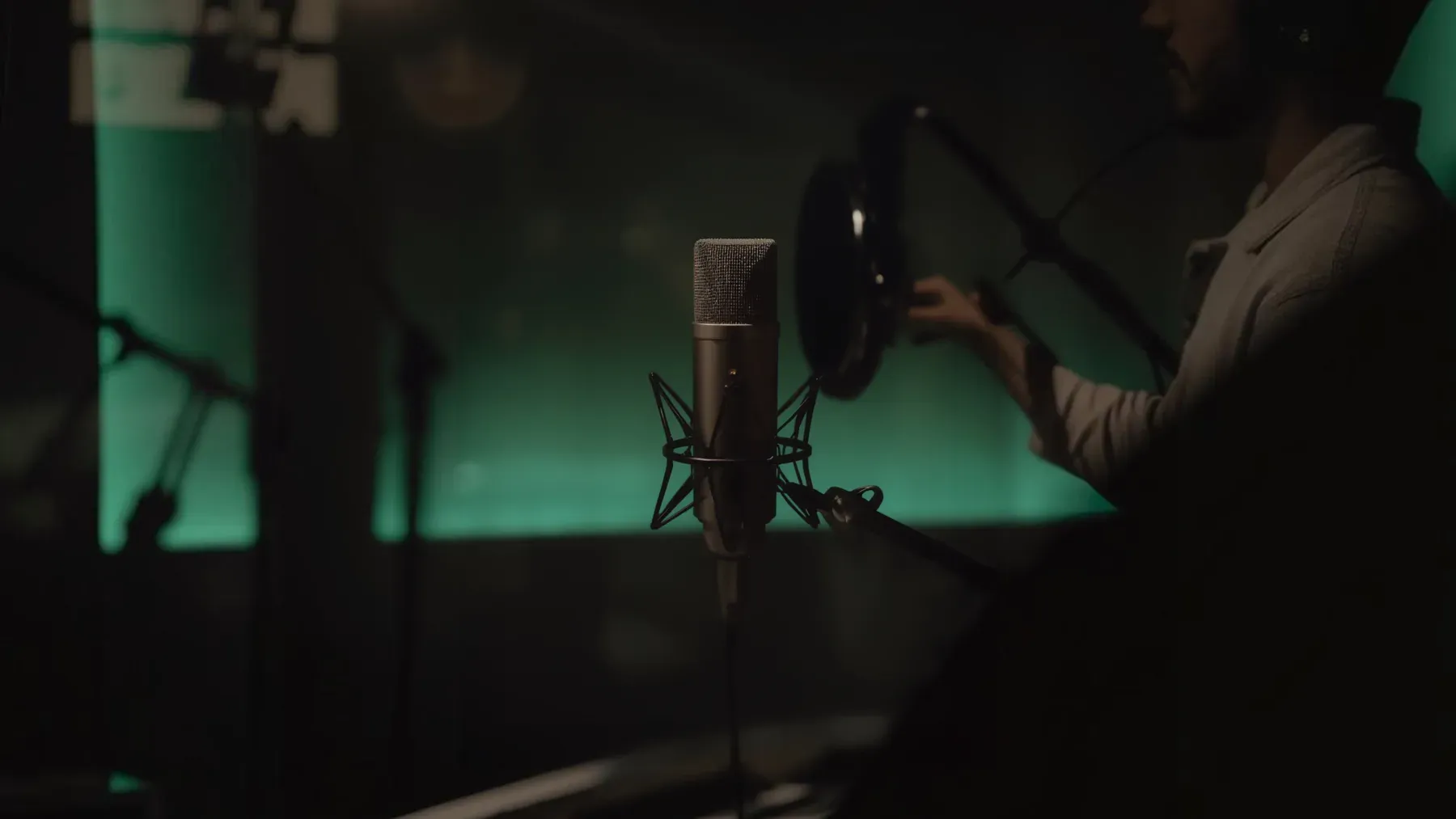 A studio microphone and shadowed performer turn music, voice, and permission into active parts of a modern descent story.