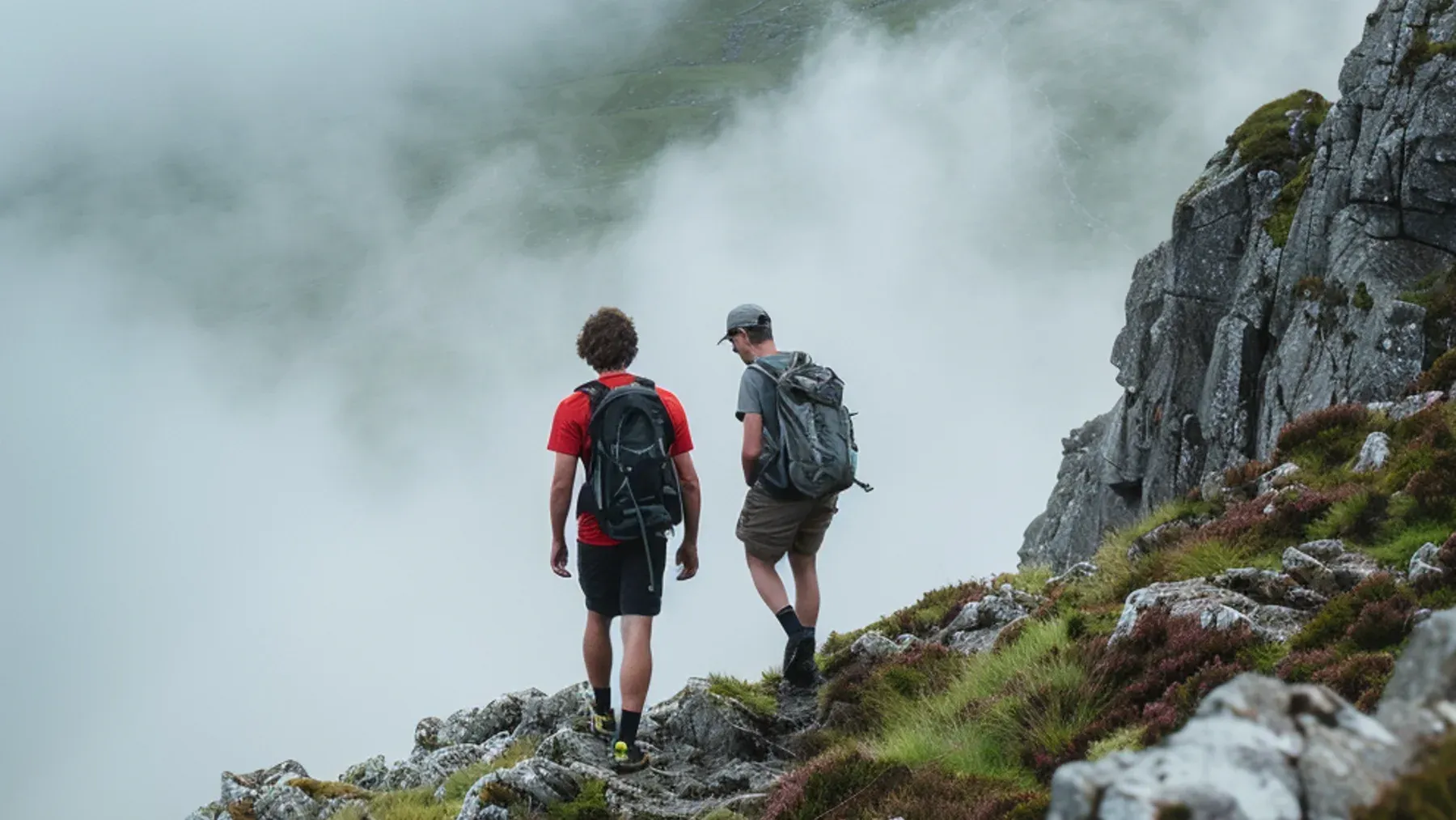 Two people cross a steep mountain route in thick cloud, representing the shared risk that one leader gradually begins to control.