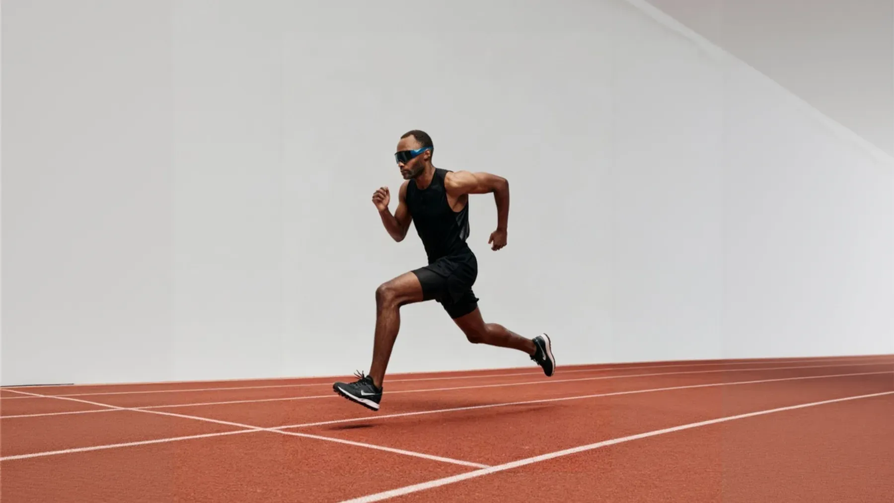 A runner training alone on a red track, representing the private repetition behind a public athletic season.