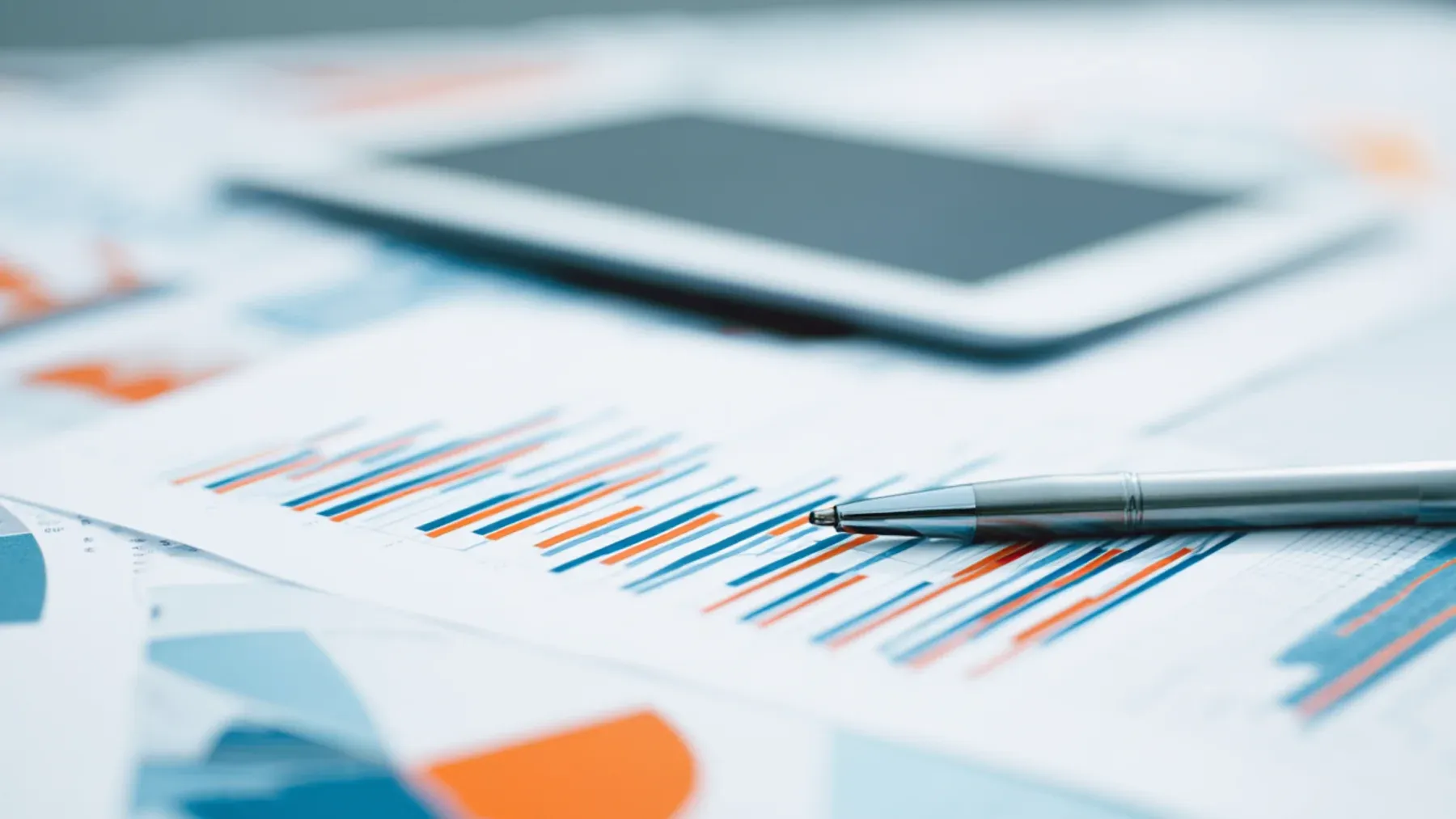 A pen and tablet rest on a report, representing the document where inferred pressure becomes a recorded decision.